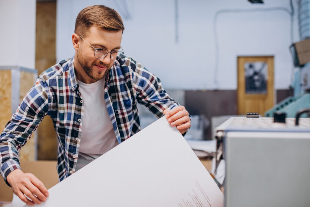 man working printing house with paper paints